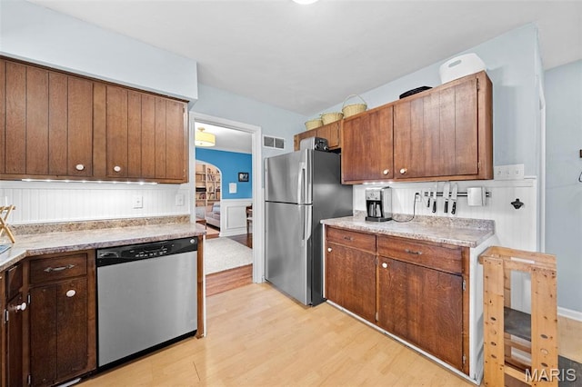100 Calverton Rd, Saint Louis, MO 63135 - kitchen featuring appliances with stainless steel finishes, light wood finished floors, wainscoting, and light countertops