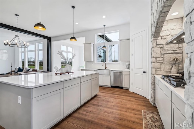 213 Bluegrass Pasture Ct, Wentzville, MO 63385 - kitchen with appliances with stainless steel finishes, wood finished floors, light countertops, a kitchen island, and pendant lighting