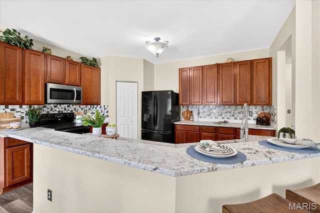 621 Royal Crest Way, Ofallon, IL 62269 - kitchen featuring black appliances, backsplash, a kitchen breakfast bar, and brown cabinetry