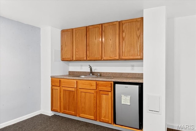 621 Royal Crest Way, Ofallon, IL 62269 - kitchen with fridge, dark carpet, and brown cabinets