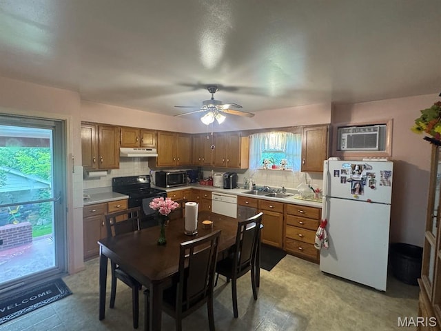737 Price St, Poplar Bluff, MO 63901 - kitchen with white appliances, under cabinet range hood, tasteful backsplash, a wall unit AC, and brown cabinetry