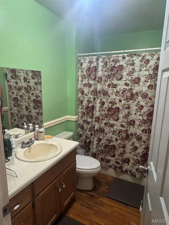 737 Price St, Poplar Bluff, MO 63901 - bathroom with vanity, wood finished floors, and a shower with curtain
