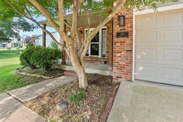 1817 Partridge Pl, Edwardsville, IL 62025 - entrance to property featuring brick siding, an attached garage, a porch, and a lawn