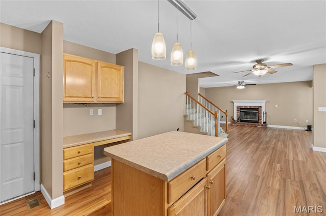 1817 Partridge Pl, Edwardsville, IL 62025 - kitchen with light wood-style flooring, built in study area, ceiling fan, a brick fireplace, and light countertops