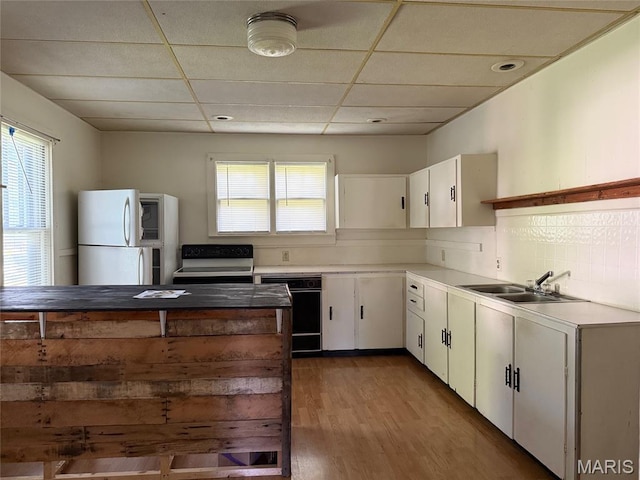 913 W Edwards St, Vandalia, IL 62471 - kitchen with freestanding refrigerator, black dishwasher, wood finished floors, electric range, and white cabinetry