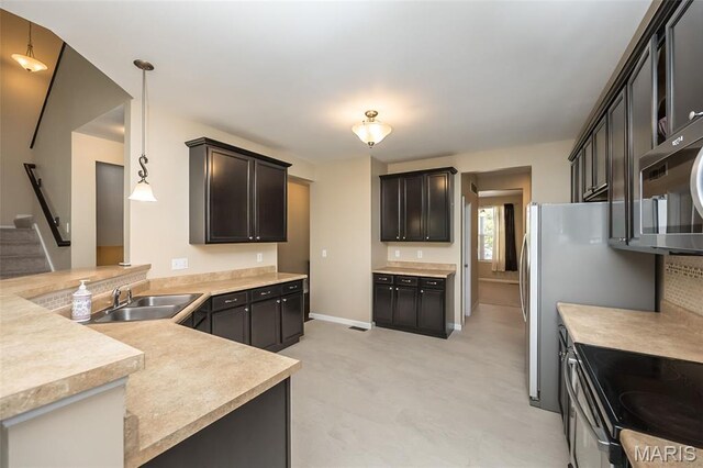 510 Newkirk Cir, Saint Charles, MO 63303 - kitchen featuring light countertops, a peninsula, appliances with stainless steel finishes, and hanging light fixtures