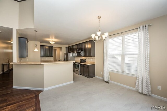 510 Newkirk Cir, Saint Charles, MO 63303 - kitchen featuring appliances with stainless steel finishes, a peninsula, light countertops, and a chandelier