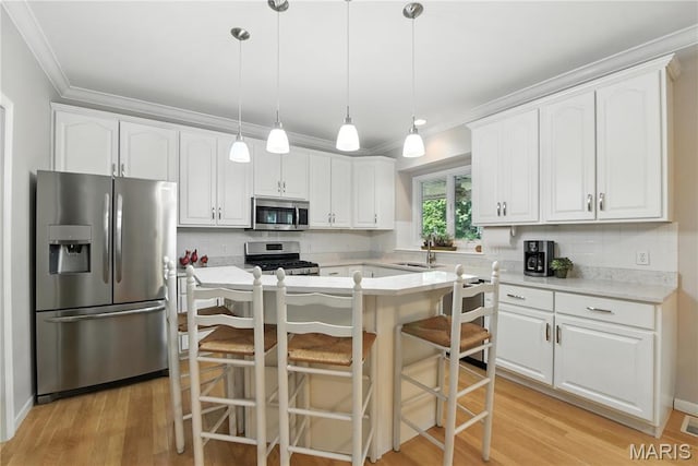 1605 High Sierra Dr, Foristell, MO 63348 - kitchen with ornamental molding, stainless steel appliances, white cabinets, decorative backsplash, and a kitchen bar