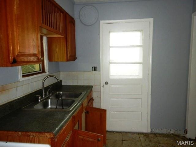 11947 Bridgevale Ave, Saint Louis, MO 63138 - kitchen with dark countertops, tile patterned floors, brown cabinets, and backsplash