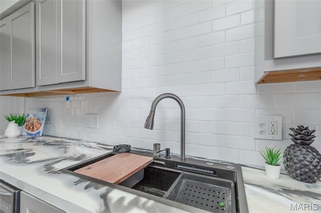 10141 Ventura Dr, Ferguson Township, MO 63136 - kitchen featuring decorative backsplash, gray cabinetry, and light countertops