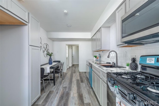 10141 Ventura Dr, Ferguson Township, MO 63136 - kitchen featuring stainless steel appliances, light wood finished floors, light countertops, and backsplash