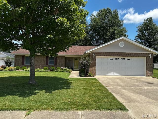 1010 Pine St, Sikeston, MO 63801 - single story home with an attached garage, brick siding, concrete driveway, and a front lawn