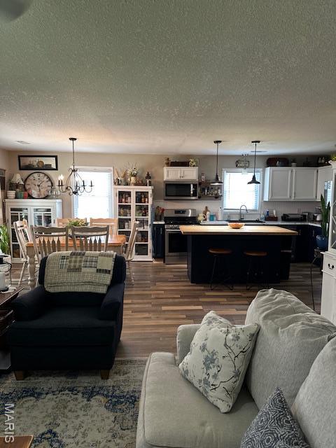 1010 Pine St, Sikeston, MO 63801 - living area featuring a textured ceiling, dark wood-type flooring, and a chandelier