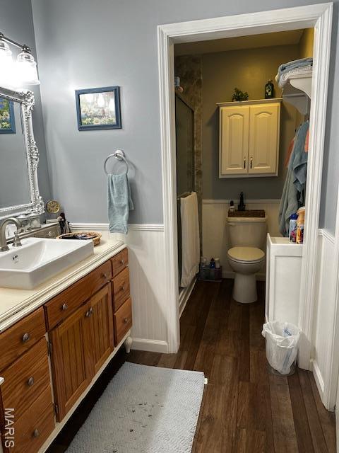 1010 Pine St, Sikeston, MO 63801 - bathroom featuring wainscoting, wood finished floors, vanity, and a stall shower