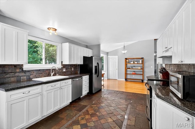 1826 Fairwood Forest Dr, Saint Peters, MO 63376 - kitchen featuring stainless steel appliances, stone tile flooring, lofted ceiling, backsplash, and white cabinets