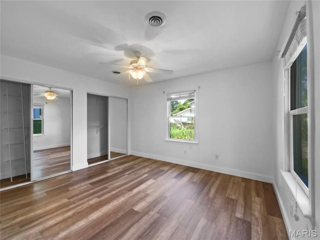 248 Ramsey Ln, Ballwin, MO 63021 - unfurnished bedroom featuring multiple closets, wood finished floors, and ceiling fan