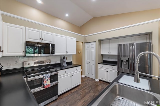 1923 Smizer Mill Rd, Fenton, MO 63026 - kitchen featuring stainless steel appliances, dark wood finished floors, dark countertops, vaulted ceiling, and decorative backsplash