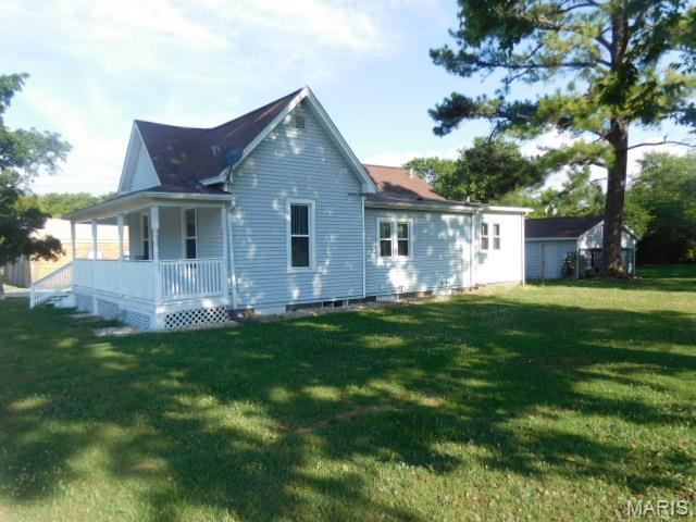 200 N Madison St, Kinmundy, IL 62854 - back of property with covered porch, a yard, and crawl space