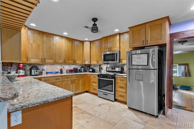 17999 State Highway 177, Jackson, MO 63755 - kitchen featuring appliances with stainless steel finishes, decorative backsplash, a ceiling fan, light stone counters, and recessed lighting