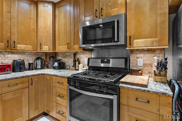17999 State Highway 177, Jackson, MO 63755 - kitchen featuring appliances with stainless steel finishes, decorative backsplash, and light stone countertops