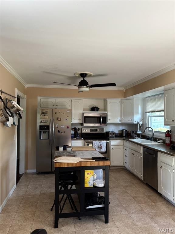 2941 Elmcrest Dr, Saint Charles, MO 63301 - kitchen featuring stainless steel appliances, crown molding, dark countertops, ceiling fan, and white cabinets
