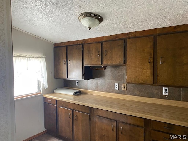 464 S Mill St, Nashville, IL 62263 - kitchen featuring a textured ceiling, light countertops, vaulted ceiling, dark brown cabinetry, and ornamental molding