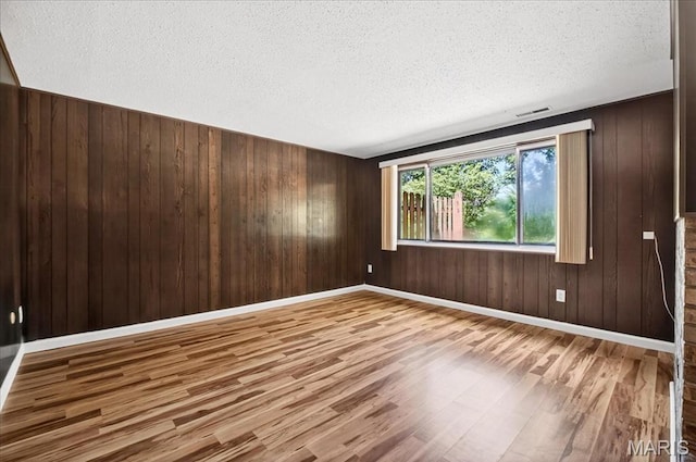 775 Knickerbacker Dr, Manchester, MO 63021 - empty room with wood finished floors, a textured ceiling, and wood walls