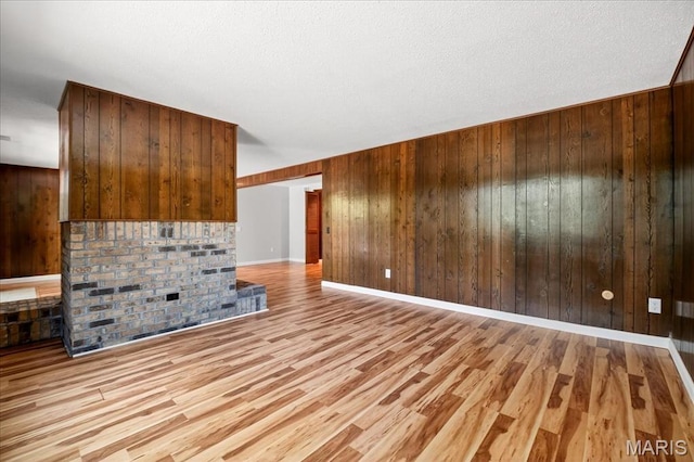 775 Knickerbacker Dr, Manchester, MO 63021 - unfurnished living room with wooden walls, light wood finished floors, and a textured ceiling