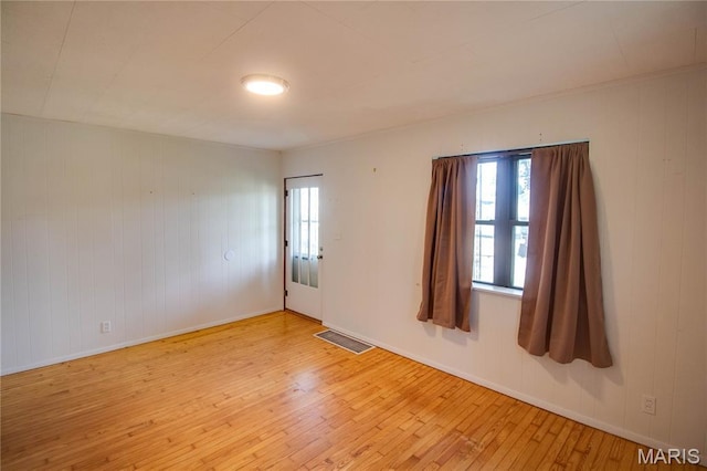 194 S Pence St, East Alton, IL 62024 - spare room with hardwood / wood-style flooring, plenty of natural light, and wooden walls