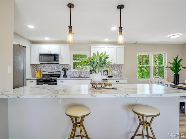 5 Chalet Ct, Fairview Heights, IL 62208 - kitchen featuring appliances with stainless steel finishes, white cabinets, tasteful backsplash, a breakfast bar, and recessed lighting