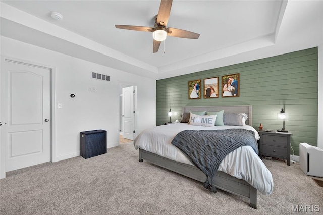 231 Flint Brook Dr, Ofallon, MO 63366 - carpeted bedroom featuring a tray ceiling, wood walls, and ceiling fan