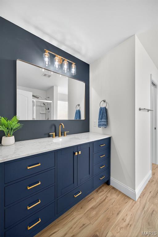231 Flint Brook Dr, Ofallon, MO 63366 - full bathroom featuring wood finished floors, vanity, and a shower