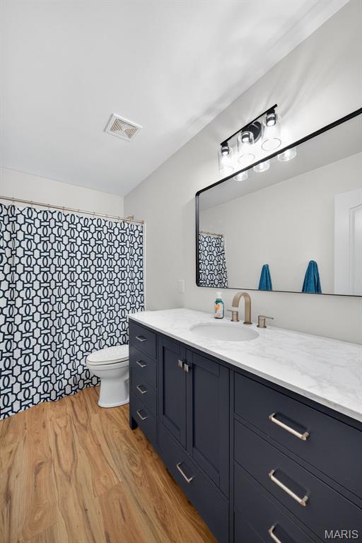 231 Flint Brook Dr, Ofallon, MO 63366 - full bath with vanity, wood finished floors, and a shower with shower curtain