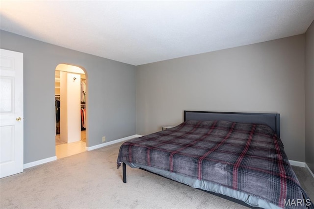 5593 Baronridge Dr Unit 7, Saint Louis, MO 63129 - carpeted bedroom featuring arched walkways and a walk in closet