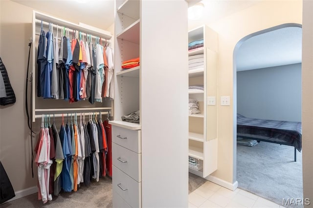 5593 Baronridge Dr Unit 7, Saint Louis, MO 63129 - walk in closet featuring light carpet and arched walkways