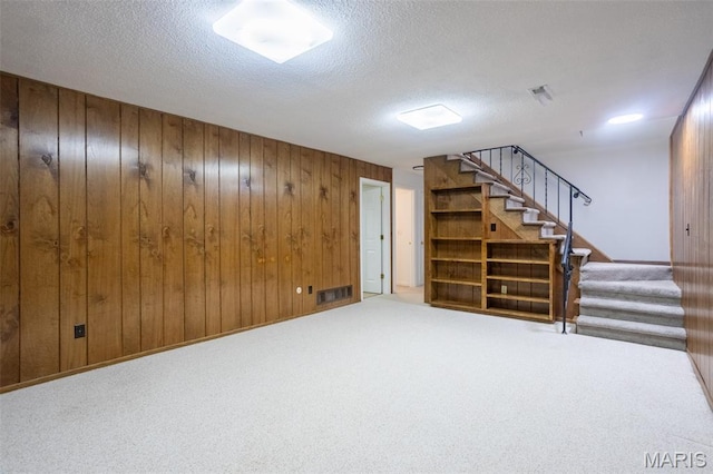 5593 Baronridge Dr Unit 7, Saint Louis, MO 63129 - finished below grade area featuring stairway, wooden walls, a textured ceiling, and carpet