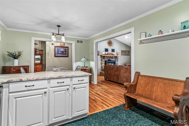 5090 Green Hills Rd, Festus, MO 63028 - kitchen with white cabinets, crown molding, light countertops, a fireplace, and light wood-style flooring