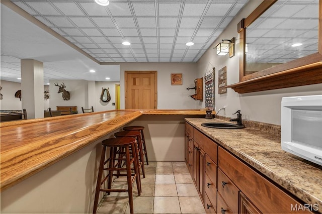5090 Green Hills Rd, Festus, MO 63028 - indoor wet bar with white microwave, light tile patterned flooring, and recessed lighting