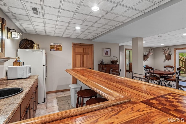 5090 Green Hills Rd, Festus, MO 63028 - kitchen with white appliances, light tile patterned floors, recessed lighting, and brown cabinets