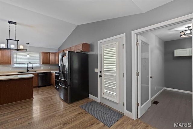 21 September St, Moscow Mills, MO 63362 - kitchen with freestanding refrigerator, dishwasher, wood finished floors, light countertops, and vaulted ceiling