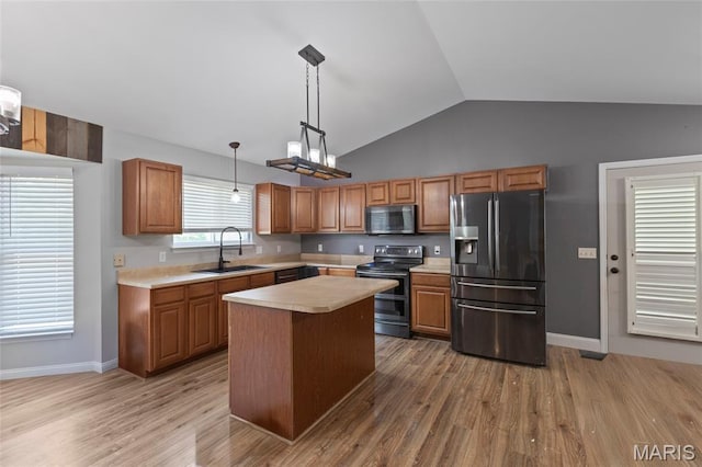 21 September St, Moscow Mills, MO 63362 - kitchen featuring appliances with stainless steel finishes, light countertops, lofted ceiling, light wood-style flooring, and decorative light fixtures