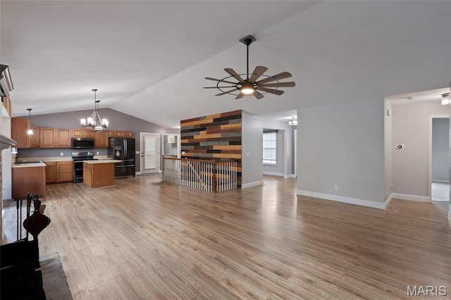 21 September St, Moscow Mills, MO 63362 - unfurnished living room with lofted ceiling, light wood-style flooring, a chandelier, and a ceiling fan
