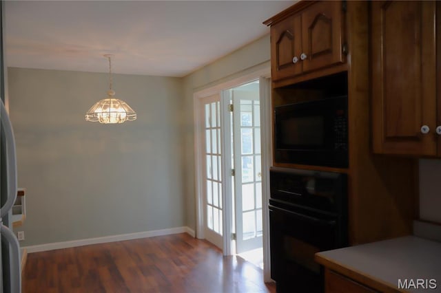 616 Greensferry Rd, Jackson, MO 63755 - kitchen featuring black appliances, wood finished floors, light countertops, pendant lighting, and brown cabinetry