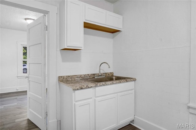 5316 Janet Ave, Jennings, MO 63136 - kitchen with white cabinetry, dark wood-style flooring, light stone counters, and a textured ceiling