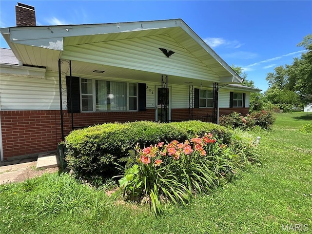 321 Walker St, Licking, MO 65542 - view of front of house featuring brick siding, a chimney, a front yard, and a porch