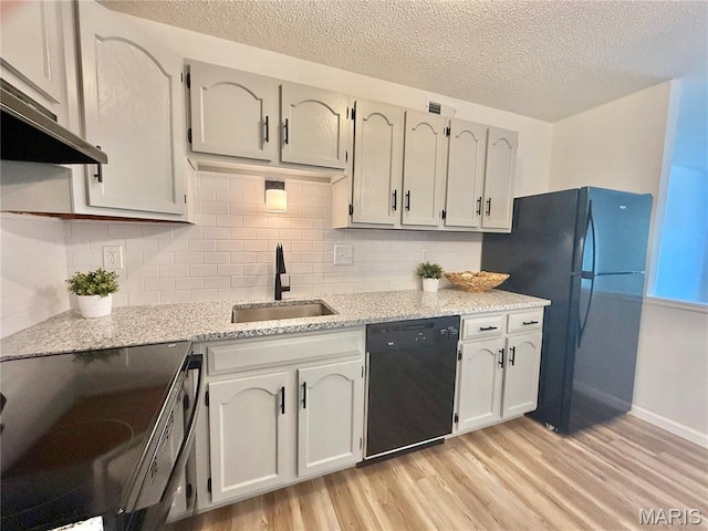 601 N Monroe St Unit 9, Pacific, MO 63069 - kitchen with black appliances, light wood-style floors, a textured ceiling, decorative backsplash, and under cabinet range hood