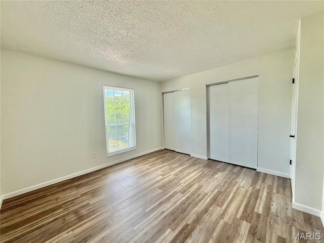 601 N Monroe St Unit 9, Pacific, MO 63069 - unfurnished bedroom featuring multiple closets, wood finished floors, and a textured ceiling