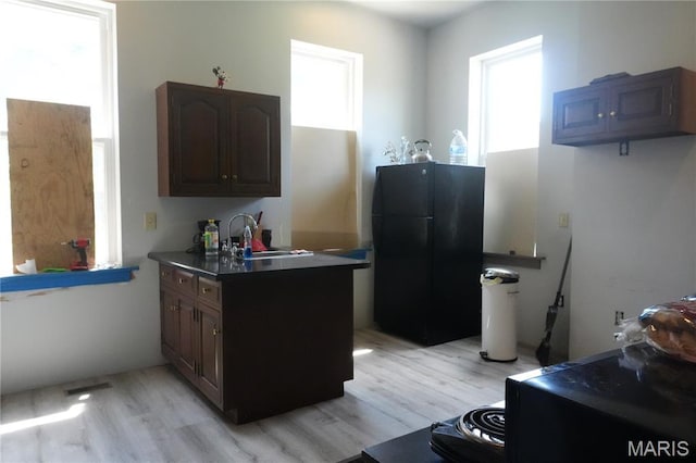 3632 Cook Ave, Saint Louis, MO 63113 - kitchen featuring freestanding refrigerator, light wood-style flooring, and a peninsula