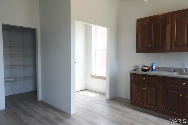 3632 Cook Ave, Saint Louis, MO 63113 - kitchen featuring light wood-style flooring, light countertops, and dark brown cabinetry