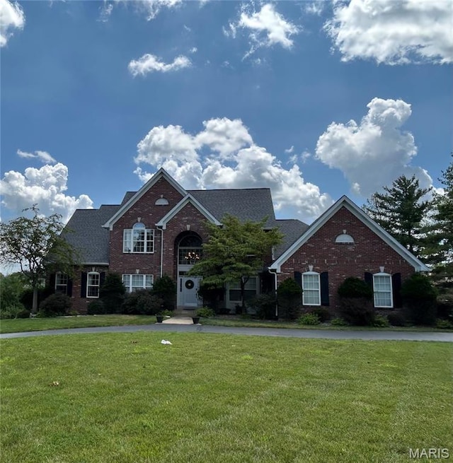 traditional-style home with brick siding and a front yard